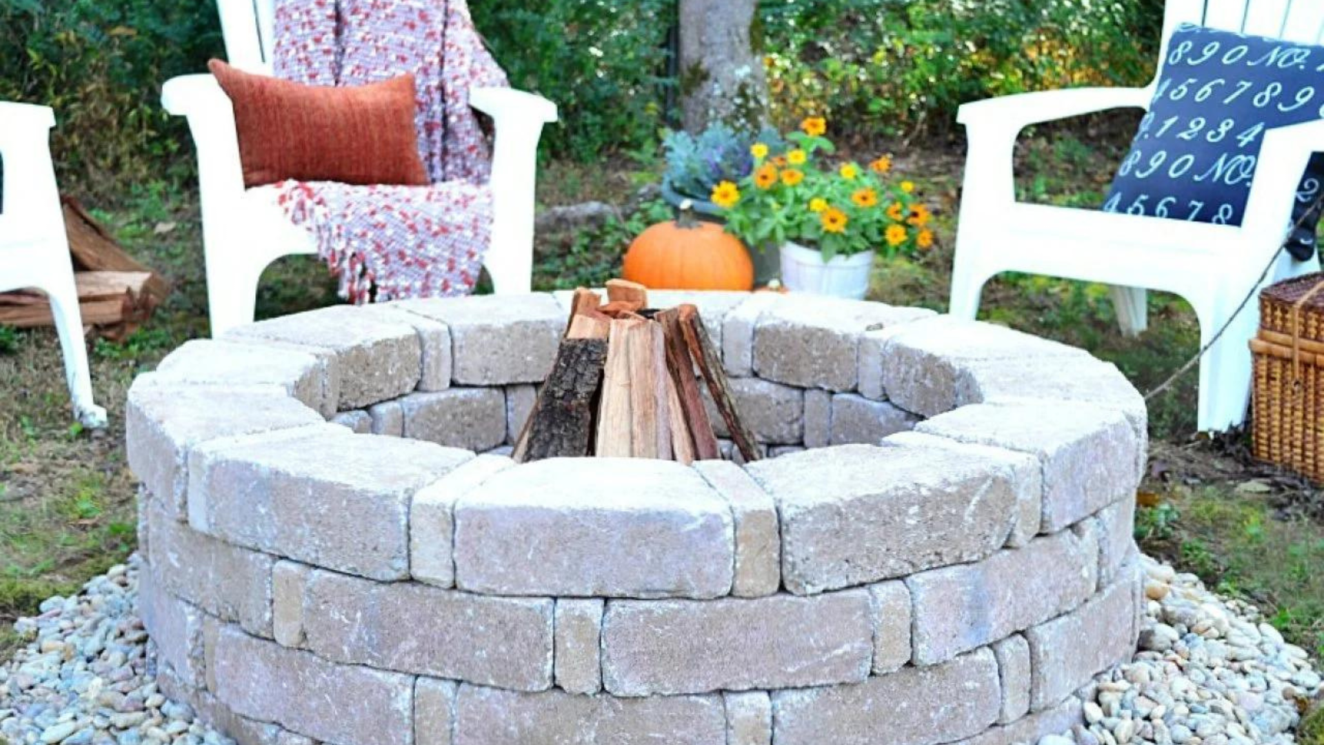 Fire pit patio with Adirondack chairs, paver surface, and landscaped lawn.