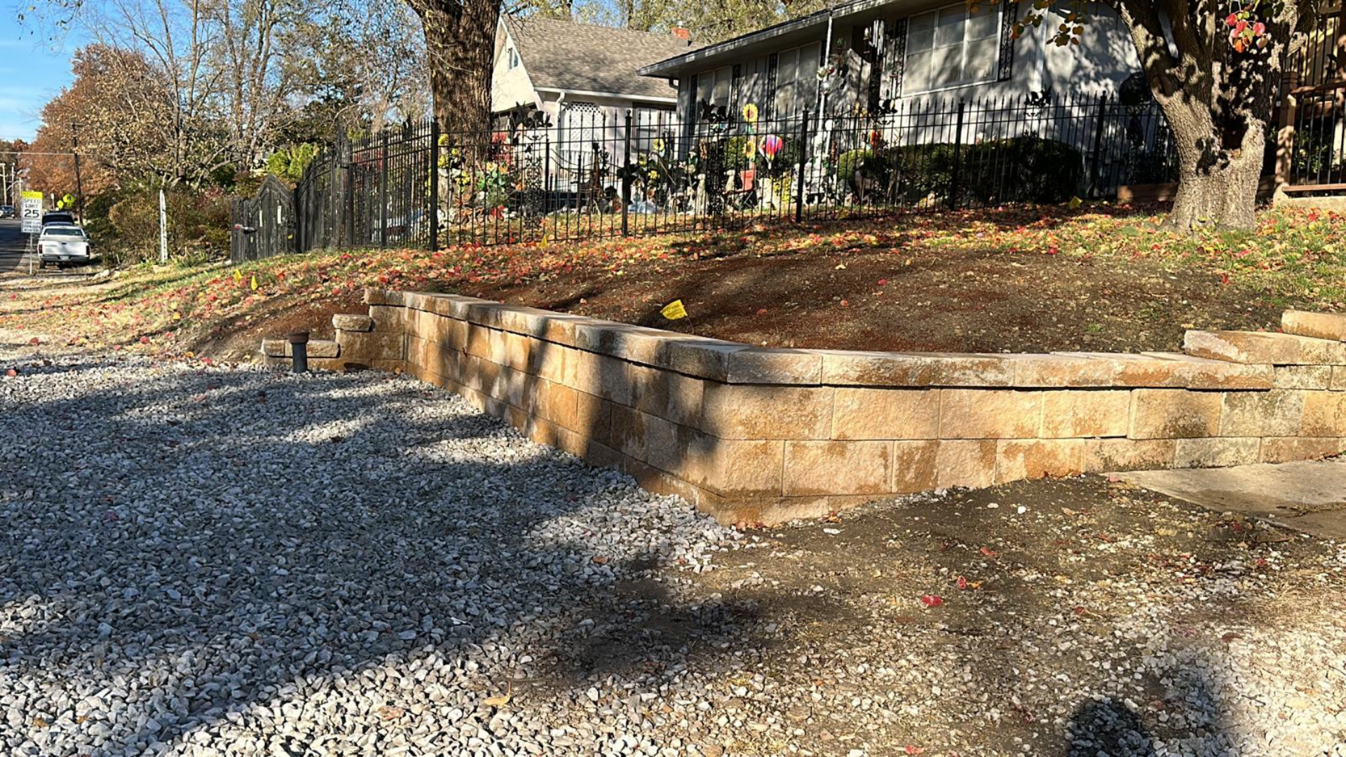 Front yard retaining wall with stone block construction along a sloped property.