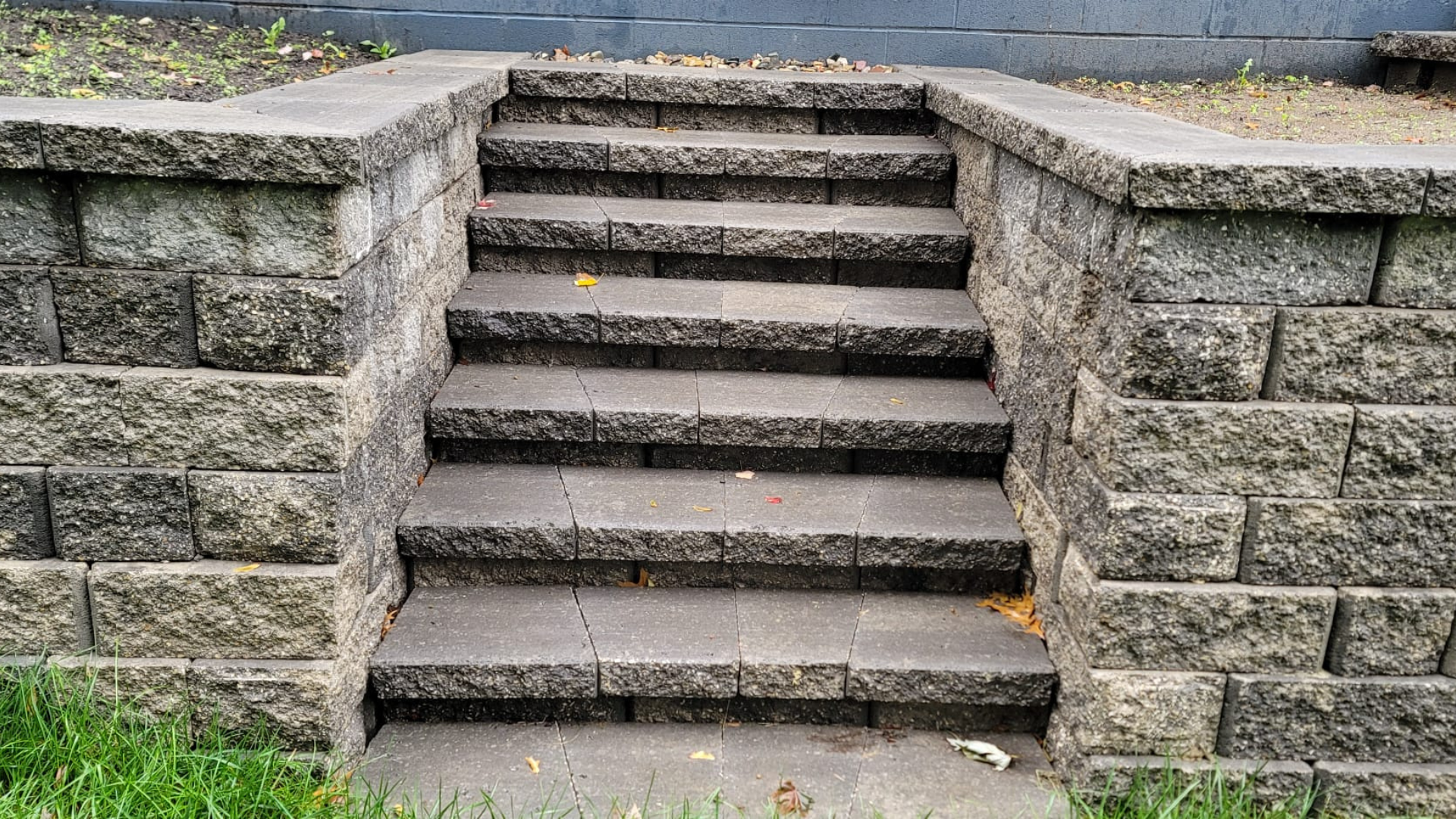 Modern paver steps with light pavers and dark border accents by home entrance.