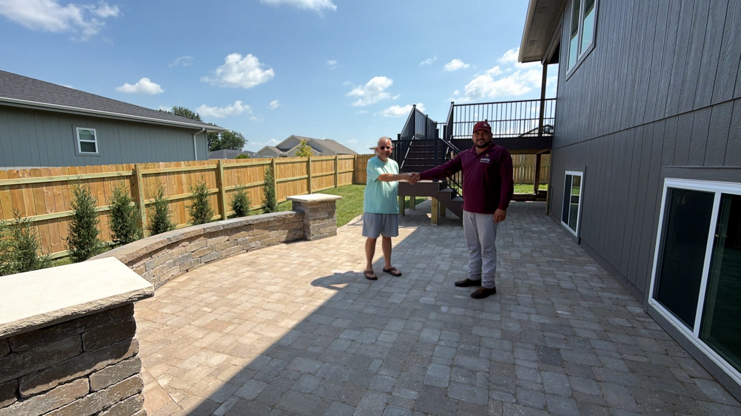 Backyard retaining wall with decorative rock and new landscape plantings