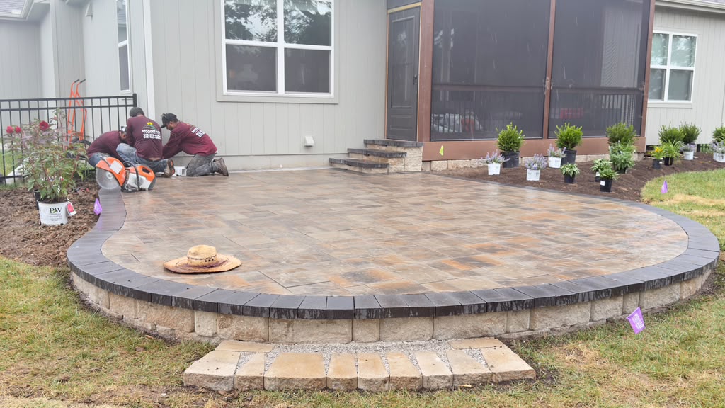 MMountain Landscaping crew installing a large paver patio with retaining wall and landscape beds